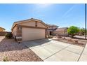 Exterior view of the home featuring desert landscaping, wide driveway and two car garage at 22569 W Lasso Ln, Buckeye, AZ 85326