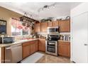 Well-lit kitchen featuring stainless steel appliances, wooden cabinets and tiled countertops at 22569 W Lasso Ln, Buckeye, AZ 85326