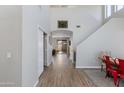 Bright foyer with wood floors leading to the living area, featuring stairs and neutral paint at 2525 W Sat Nam Way, Phoenix, AZ 85086