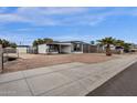 Single-story home with a carport, desert landscaping, small shed, and fenced yard at 2570 W Scenic St, Apache Junction, AZ 85120