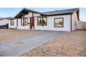 Charming single-story home featuring a red front door and gravel landscaping at 2834 N 65Th Ave, Phoenix, AZ 85035