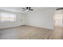 Bright living room featuring new light wood flooring, a ceiling fan, and freshly painted white walls at 2834 N 65Th Ave, Phoenix, AZ 85035