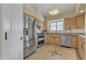 Bright kitchen featuring stainless steel appliances, tiled floors, and light wood cabinets at 3015 E Nora St, Mesa, AZ 85213