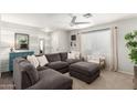 Living room with a large grey sectional sofa, white walls with grey accents, and a ceiling fan at 337 S Leandro --, Mesa, AZ 85208