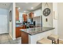 Kitchen with stainless steel refrigerator, granite counters, breakfast bar, and wood cabinetry at 3434 E Avalon Dr, Phoenix, AZ 85018