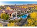 Backyard view of luxury home with pool, desert landscaping, and mountain views at 37505 N 104Th Pl, Scottsdale, AZ 85262