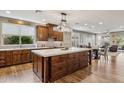 Spacious kitchen with wood cabinets, a large island, quartz countertops, and stainless steel appliances at 41208 N Prestancia Dr, Anthem, AZ 85086