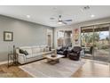 Bright living room boasts neutral tones, comfortable seating, and a sliding door to the outdoor patio at 41208 N Prestancia Dr, Anthem, AZ 85086