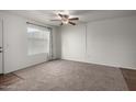 Living room featuring a ceiling fan, carpet flooring, and a large window for natural light at 461 W Holmes Ave # 277, Mesa, AZ 85210