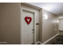 Hallway view of the front door adorned with a decorative red heart wreath in unit #2236 at 5350 E Deer Valley Dr # 2236, Phoenix, AZ 85054