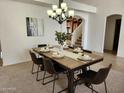 Staged dining room featuring a wooden table, black chairs, and a modern chandelier at 5381 W Del Rio St, Chandler, AZ 85226