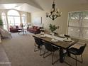 Open-concept living and dining areas with a dining table, six chairs, and modern decor at 5381 W Del Rio St, Chandler, AZ 85226