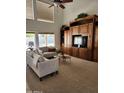 Vaulted living room featuring a large entertainment center, neutral sofa, and bright windows at 5381 W Del Rio St, Chandler, AZ 85226