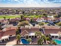 Aerial view of a neighborhood showcasing the golf course, community pool, and mature trees at 6118 E Star Valley St, Mesa, AZ 85215