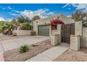 Exterior shot of stucco house with a two-car garage, gated entry, and drought-tolerant landscaping at 619 E Jensen St # 80, Mesa, AZ 85203