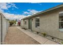 A quaint stucco home with a walkway and desert-friendly landscaping, enhanced by a secure gated entry at 619 E Jensen St # 80, Mesa, AZ 85203