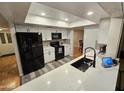 Modern kitchen featuring white cabinets, black appliances and stone countertops at 8227 N 47Th Dr, Glendale, AZ 85302