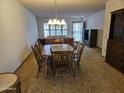 Cozy dining room showcasing a wooden table, carpet flooring, and a chandelier at 9847 W Silver Bell Dr, Sun City, AZ 85351