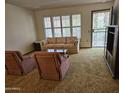 Cozy living room featuring a comfortable sofa, chairs, and natural light from the windows at 9847 W Silver Bell Dr, Sun City, AZ 85351