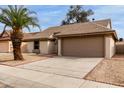 Lovely one-story home featuring low-maintenance desert landscaping, a two car garage, and sidewalk at 10135 W Orange Dr, Glendale, AZ 85307