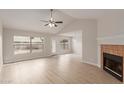 Bright living room with vaulted ceilings, new floors, a fireplace, and backyard access at 10135 W Orange Dr, Glendale, AZ 85307