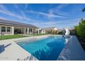 Backyard pool with a slide and pavers, surrounded by artificial turf and a black fence at 1265 E La Fortuna Ct, San Tan Valley, AZ 85140