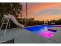 Backyard swimming pool with a slide and sleek lounge area surrounded by desert landscape at 1265 E La Fortuna Ct, San Tan Valley, AZ 85140