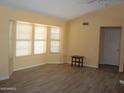 Bright living room featuring wood-look tile floors, neutral paint, and a large window at 14626 W Antelope Dr, Sun City West, AZ 85375