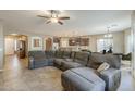 Comfortable living room with a large sectional sofa and tile flooring at 16830 W Magnolia St, Goodyear, AZ 85338