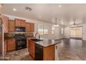 This kitchen features an island, appliances, tile floors and connects to the dining and living areas at 18072 W Vogel Ave, Waddell, AZ 85355