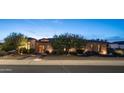 Charming exterior of a stone-clad home featuring manicured landscaping, attractive lighting, and inviting curb appeal at 2224 N 83Rd Cir, Mesa, AZ 85207