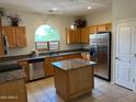 Eat-in kitchen featuring wooden cabinets, stainless steel appliances, and granite countertops at 24638 N 65Th Ave, Glendale, AZ 85310