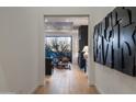 Modern hallway with light wood floors, contemporary art, and a view into a stylishly furnished living space at 37200 N Cave Creek Rd # 1035, Scottsdale, AZ 85262