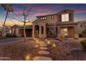 Inviting two-story home featuring warm exterior lighting, a stone walkway, and a well-maintained landscape at 3777 E Latham Ct, Gilbert, AZ 85297