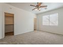 Spacious carpeted bedroom with ceiling fan, natural light, and walk-in closet at 3894 E Palmer St, Gilbert, AZ 85298