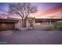 Desert home at sunset with drought tolerant desert landscaping and a circular driveway leading to the front entrance at 41353 N 106Th St, Scottsdale, AZ 85262