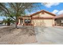Traditional tan home featuring a two-car garage, desert landscaping, and a low-maintenance front yard at 5622 E Emerald Cir, Mesa, AZ 85206
