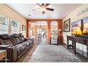 Inviting living room with a cozy leather sofa, ceiling fan, neutral color palette, and tile floors at 5622 E Emerald Cir, Mesa, AZ 85206