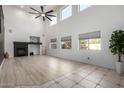 Bright, open living room with large windows, a fireplace, and modern ceiling fan at 6312 W Villa Linda Dr, Glendale, AZ 85310