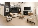 Bright living room boasts a cozy fireplace, modern furnishings, and a stunning staircase at 6312 W Villa Linda Dr, Glendale, AZ 85310