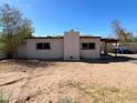Rear exterior view of a home with a brick chimney and covered patio needing repairs at 6408 S 10Th St, Phoenix, AZ 85042