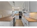 An updated kitchen with stainless steel appliances, tile backsplash and white cabinets at 7430 E Chaparral Rd # A239, Scottsdale, AZ 85250
