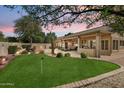 Backyard featuring a putting green, a covered patio, and mature landscaping at 8960 W Kerry Ln, Peoria, AZ 85382
