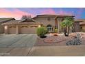 Charming single-story home with a three-car garage and desert landscaping for curb appeal at 8960 W Kerry Ln, Peoria, AZ 85382
