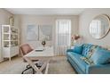 A cozy home office with a stylish blue sofa, white desk, and natural light creates a productive workspace at 9910 E Theia Dr, Mesa, AZ 85212