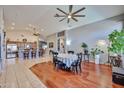 An open dining room with hardwood floors and an adjacent kitchen with stainless steel appliances, creating a welcoming atmosphere at 12814 W Windrose Dr, El Mirage, AZ 85335