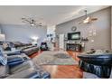 Open-concept living room featuring hardwood floors, a ceiling fan, and stylish decor with plenty of room for entertaining at 12814 W Windrose Dr, El Mirage, AZ 85335