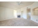 Bright living room featuring neutral carpet, a ceiling fan, and a fireplace at 1331 W Baseline Rd # 340, Mesa, AZ 85202