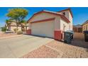 A two car garage in front of a home with desert landscaping at 13321 N 124Th Ave, El Mirage, AZ 85335