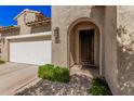 Inviting front entrance with an arched doorway and desert landscaping at 1446 E Canary Dr, Gilbert, AZ 85297